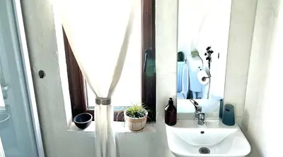 a white bathroom with a sink and a mirror at Къща Христини in Kalofer