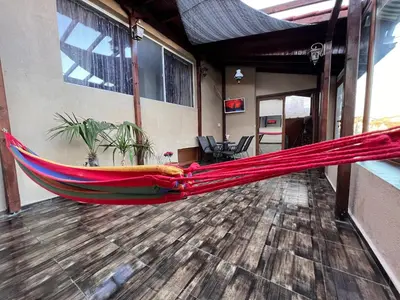 a red hammock on a floor in a room at Къща за гости Шарон in Petrich