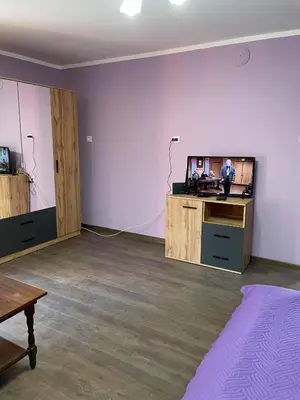 an empty living room with a tv and a table at Къща за гости Станеви in Ribarica