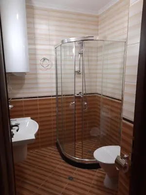 a bathroom with a shower and a toilet and a sink at Апартамент в MountainLake in Smolyan