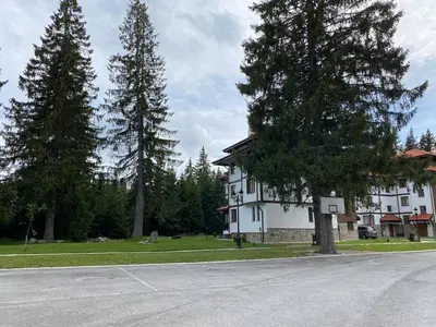 a large white building with trees in front of it at Апартамент в MountainLake in Smolyan