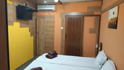 a small room with two beds and a television at Къща за гости Вишнева градина in Brestnik