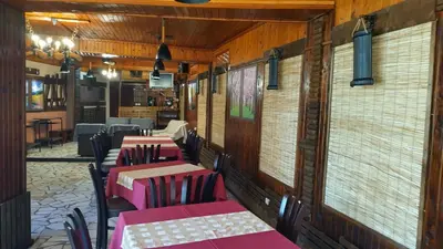 a row of tables and chairs in a restaurant at Къща за гости Вишнева градина in Brestnik