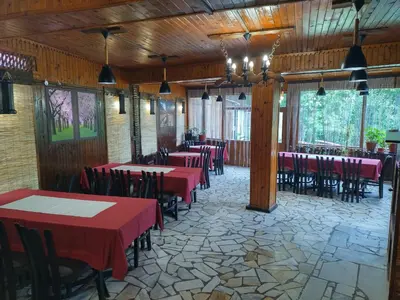 a dining room with red tables and chairs at Къща за гости Вишнева градина in Brestnik