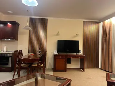 a living room with a television and a table with a dining room at Bardarova Apartments Downtown Bansko in Bansko