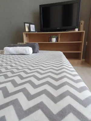 a bedroom with a bed and a flat screen tv at Nights apartment in Sofia