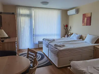 a bedroom with a bed and a table and chairs at Студио за трима, басейн, Aspen Golf Resort, Банско, Разлог in Razlog