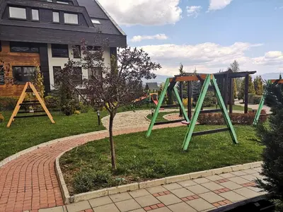 a playground with a swing set in a yard at Студио за трима, басейн, Aspen Golf Resort, Банско, Разлог in Razlog