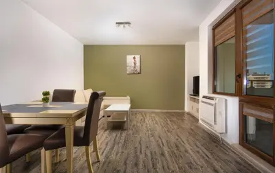 a dining room with a table and chairs and a television at 1BD Flat with a lovely terrace in the centre of Plovdiv by Flat Mаnager in Plovdiv