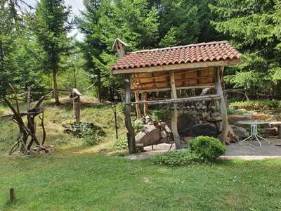 a wooden gazebo in a yard with a table at Апартамент Лейк Вю, вила Флора, комплекс Маунтин лейк in Smolyan