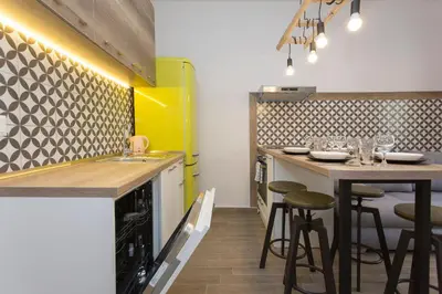 a kitchen with two bar stools and a yellow refrigerator at Sunny and Modern 1BDR Apartment in the Center in Sofia