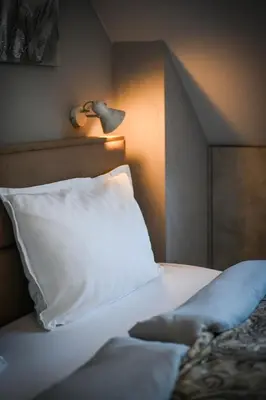 a bed with a white pillow and a lamp at Cloud 6 -Top Center,360° view,Free private parking in Plovdiv