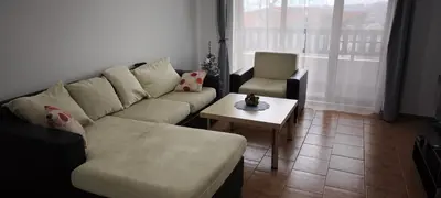 a living room with a couch and a table and a chair at Старият Хан-Б24 in Bansko