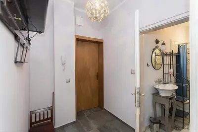 a hallway with a bathroom with a sink and a door at Colorful 2BDR Apartment in the City Center in Sofia