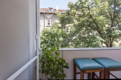 a pair of stools sitting on a balcony with a window at Colorful 2BDR Apartment in the City Center in Sofia