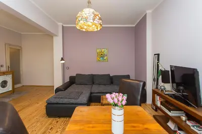 a living room with a couch and a table with flowers at Colorful 2BDR Apartment in the City Center in Sofia