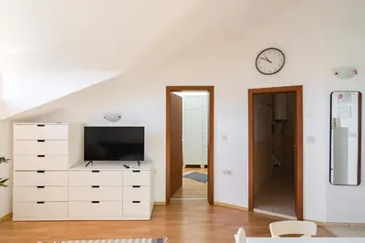a living room with a white dresser and a clock at Todorka Apartments in Bansko in Bansko