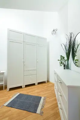 a kitchen with white cabinets and a blue rug at Todorka Apartments in Bansko in Bansko