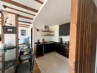 a kitchen with black cabinets and a table and chairs at Luxury Apartment Pirin Chalet in Terra Complex in Bansko