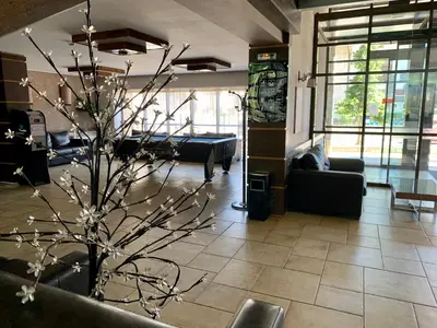 a lobby with a potted tree in the middle of a room at Luxury Apartment Pirin Chalet in Terra Complex in Bansko