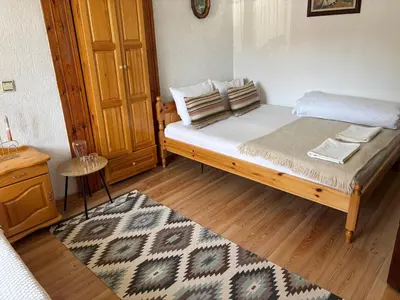 a bedroom with a bed and a wooden floor at Къща за гости Иглика in Trigrad