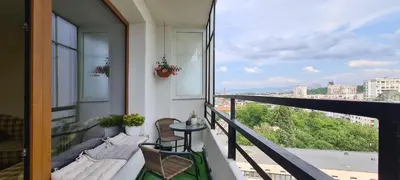 a balcony with a couch and a table on a balcony at Panoramic and Spacious Flat near the City Centre in Sofia