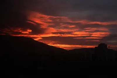 a sunset in the sky over a city at Panoramic and Spacious Flat near the City Centre in Sofia