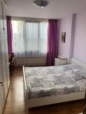 a bedroom with a bed and a window with purple curtains at Apart 47 in Smolyan