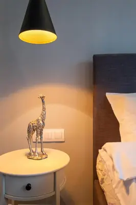 a statue of a giraffe on a table next to a bed at Designer & Cozy 2BD Flat with a parking in the city center by Flat Mаnager in Sofia