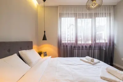 a bedroom with a large white bed with towels on it at Designer & Cozy 2BD Flat with a parking in the city center by Flat Mаnager in Sofia