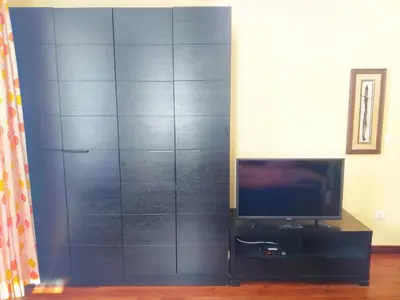 a living room with a tv and a black wall at Стаи за Гости Lavender Lozen in Lozen