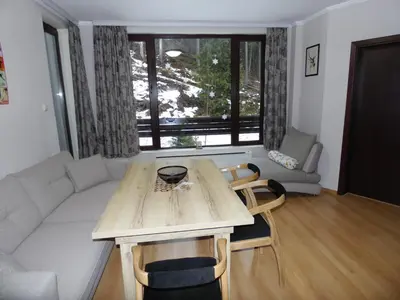 a living room with a table and a couch at Deer's Home at Elit Pamporovo in Pamporovo