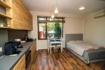 a bedroom with a bed and a kitchen with a table at Exclusive Top Central Studio in Sofia