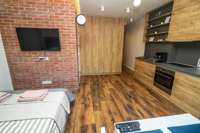 a room with a brick wall and a kitchen with a tv at Exclusive Top Central Studio in Sofia