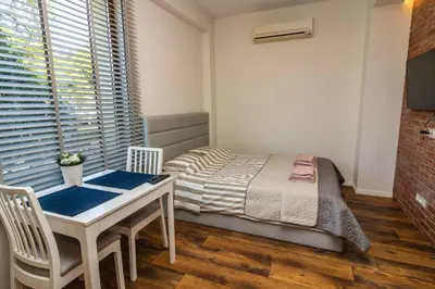 a bedroom with a bed and a table with chairs at Exclusive Top Central Studio in Sofia