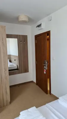 a bedroom with a door and a mirror at Hotel Geppy in Sofia