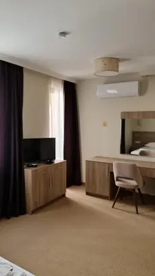 a bedroom with a bed and a desk and a chair at Hotel Geppy in Sofia