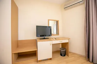 a room with a desk with a television on it at Hotel Astra in Sandanski