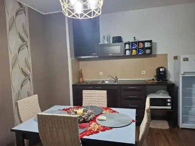a kitchen with a table and chairs and a kitchen with a sink at Илен 433 Bansko Royal Towers in Bansko