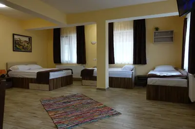 a hotel room with three beds and a rug at Борник Хил / Bornik Hill in Devin