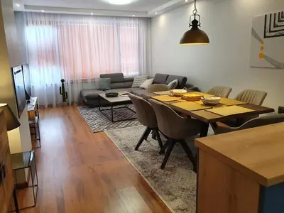 a living room with a table and a couch at Monteverde Ski Lift Apartment Bansko in Bansko