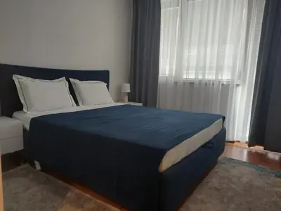 a bedroom with a large bed with a blue blanket at Monteverde Ski Lift Apartment Bansko in Bansko
