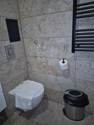 a bathroom with a toilet and a trash can at Monteverde Ski Lift Apartment Bansko in Bansko