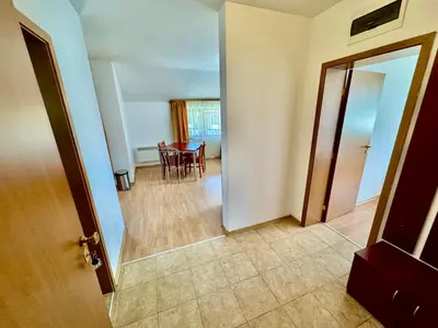 a hallway with a table and chairs in a room at Todorini Kuli Apartments in Bansko