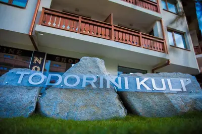 a sign that reads topomiki kunk in front of a building at Todorini Kuli Apartments in Bansko