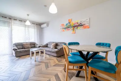 a living room with a table and a couch at Sunny Apartment in Studentski grad, behind UNSS in Sofia