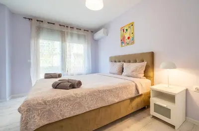 a bedroom with a large bed and a window at Sunny Apartment in Studentski grad, behind UNSS in Sofia