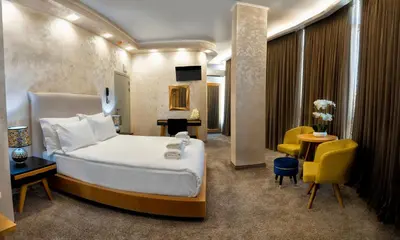 a hotel room with a bed and a table and chairs at Hotel CITY Petrich in Petrich