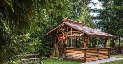 a tree house in a park with a bench at Studio by Mountain Lakes in Ezerovo