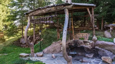 a small wooden structure in the middle of a garden at Studio by Mountain Lakes in Ezerovo